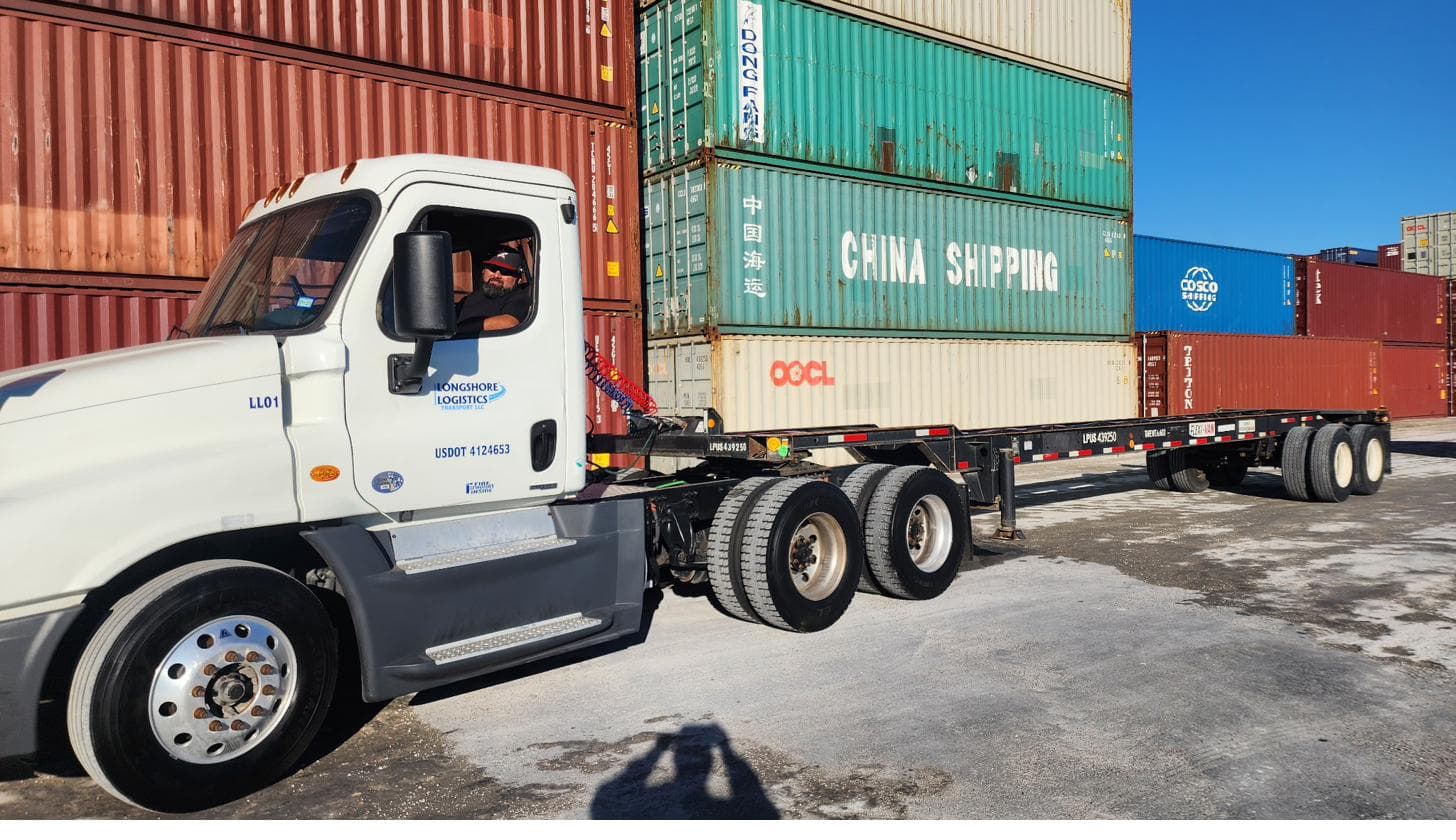 Longshore Logistics white truck connected to a container chassis in a container yard